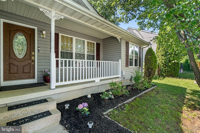 view of exterior entry featuring covered porch
