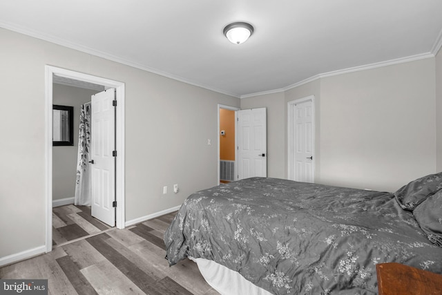 bedroom featuring wood finished floors, ornamental molding, and baseboards