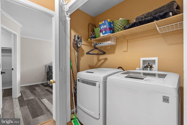 laundry room featuring wood finished floors, washing machine and clothes dryer, and baseboards