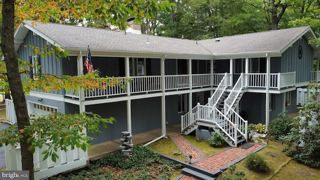 115 Carnoustie Rd, Dover, DE 19904 - back of house with a sunroom, a shingled roof, a chimney, and board and batten siding
