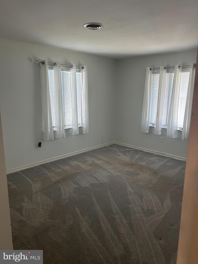 115 Carnoustie Rd, Dover, DE 19904 - empty room featuring baseboards, a wealth of natural light, and dark colored carpet