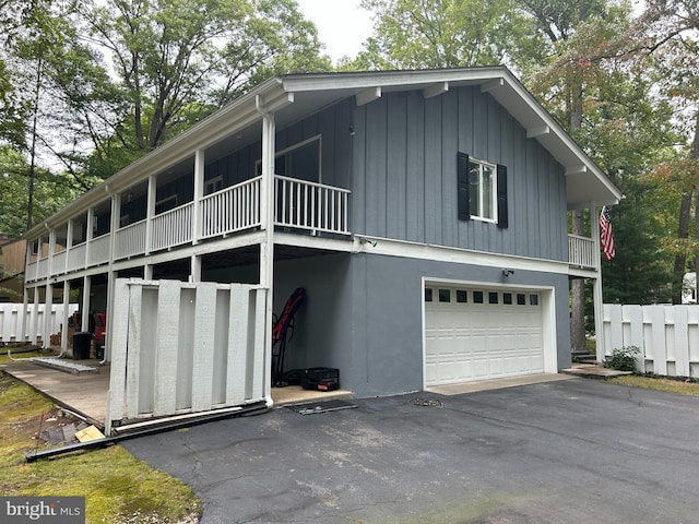 115 Carnoustie Rd, Dover, DE 19904 - exterior space with aphalt driveway, fence, an attached garage, stucco siding, and board and batten siding