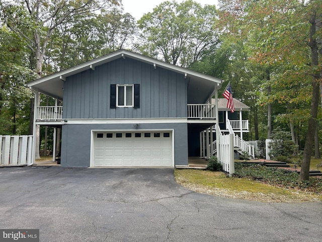 115 Carnoustie Rd, Dover, DE 19904 - view of front of home with stucco siding, a garage, aphalt driveway, and stairs