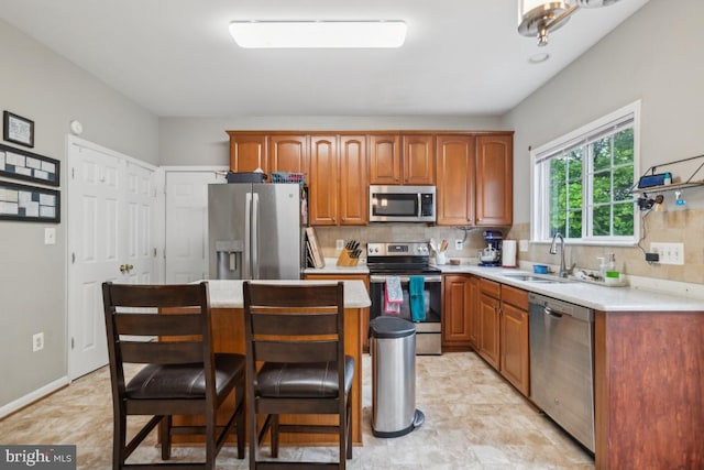 8645 Adrienne Pl, Manassas, VA 20110 - kitchen featuring appliances with stainless steel finishes, a sink, light countertops, and backsplash