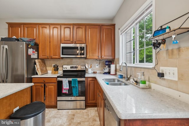 8645 Adrienne Pl, Manassas, VA 20110 - kitchen featuring appliances with stainless steel finishes, a sink, brown cabinetry, and decorative backsplash