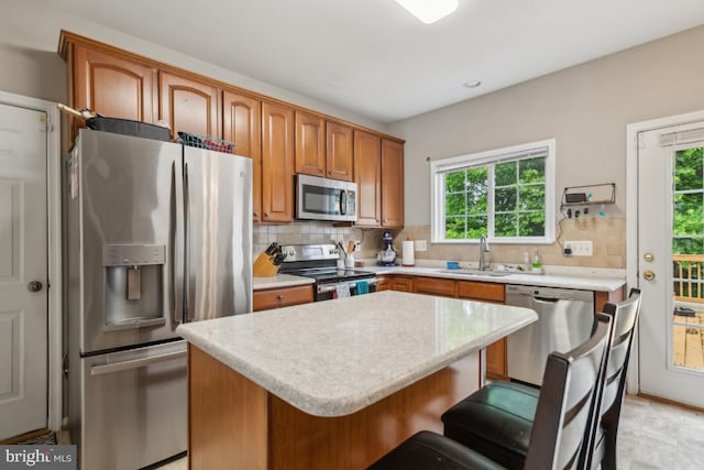 8645 Adrienne Pl, Manassas, VA 20110 - kitchen with appliances with stainless steel finishes, a sink, backsplash, and a kitchen breakfast bar