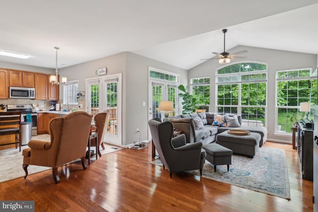 8645 Adrienne Pl, Manassas, VA 20110 - living room featuring healthy amount of natural light, light wood-style flooring, ceiling fan, vaulted ceiling, and french doors