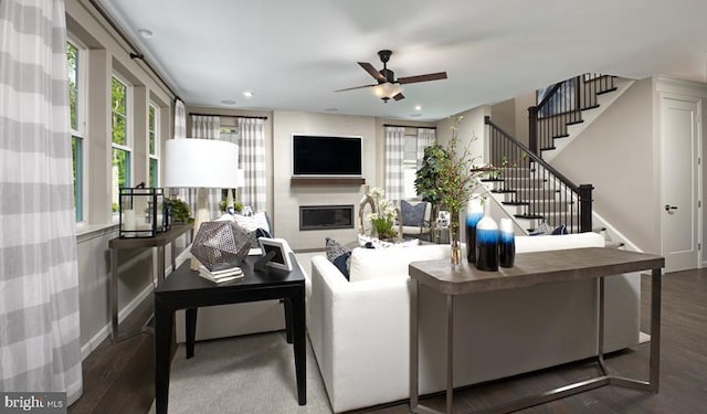 living room with stairs, wood finished floors, recessed lighting, ceiling fan, and a glass covered fireplace