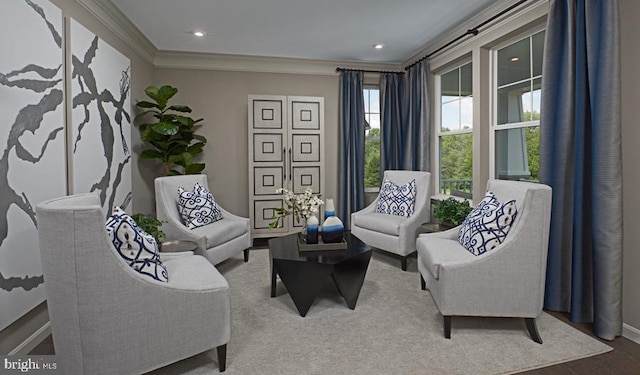 sitting room with ornamental molding, baseboards, and wood finished floors