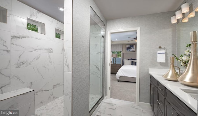 full bathroom with double vanity, a marble finish shower, a ceiling fan, ensuite bathroom, and marble finish floor
