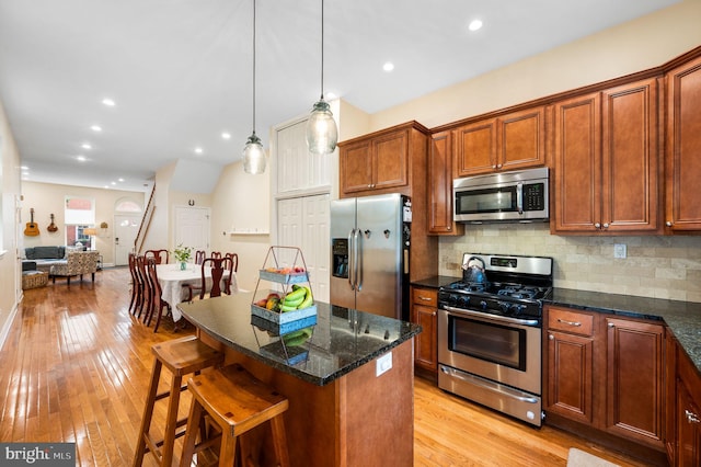866 N 20th St, Philadelphia, PA 19130 - kitchen featuring stainless steel appliances, light wood-type flooring, decorative backsplash, a breakfast bar, and recessed lighting