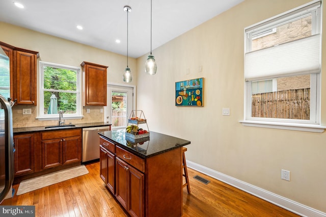 866 N 20th St, Philadelphia, PA 19130 - kitchen featuring dishwasher, a sink, light wood-style floors, baseboards, and decorative backsplash