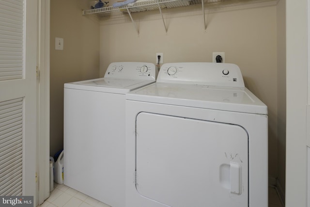 clothes washing area with separate washer and dryer, laundry area, and light tile patterned floors