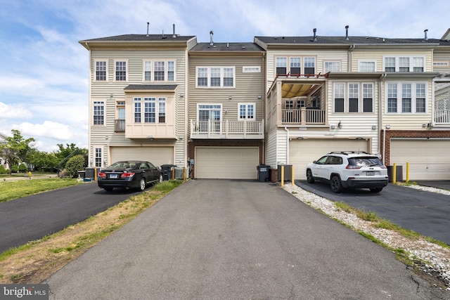 rear view of property featuring driveway and an attached garage