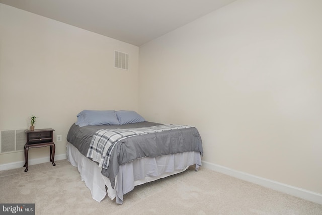 bedroom featuring visible vents, baseboards, and light carpet