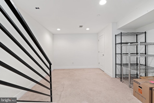 below grade area featuring visible vents, baseboards, stairway, light carpet, and recessed lighting