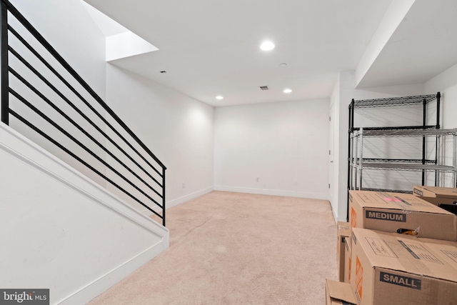 basement featuring stairway, light carpet, baseboards, and recessed lighting