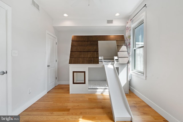 interior space featuring visible vents, light wood-style flooring, and baseboards