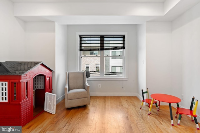 living area with baseboards and wood finished floors
