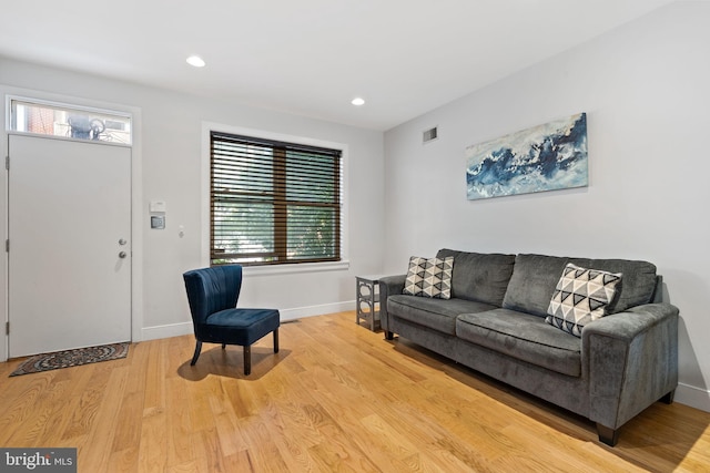 living room with light wood finished floors, visible vents, baseboards, and recessed lighting