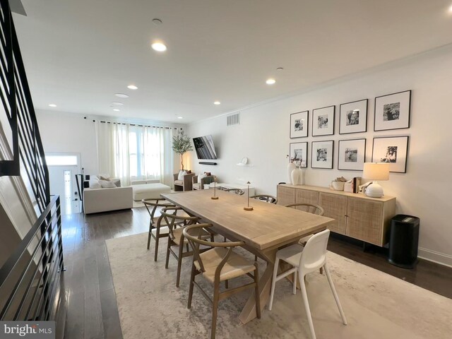 dining space featuring dark wood-style flooring, recessed lighting, and ornamental molding