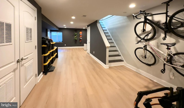 corridor with light wood-style flooring, baseboards, recessed lighting, and stairs