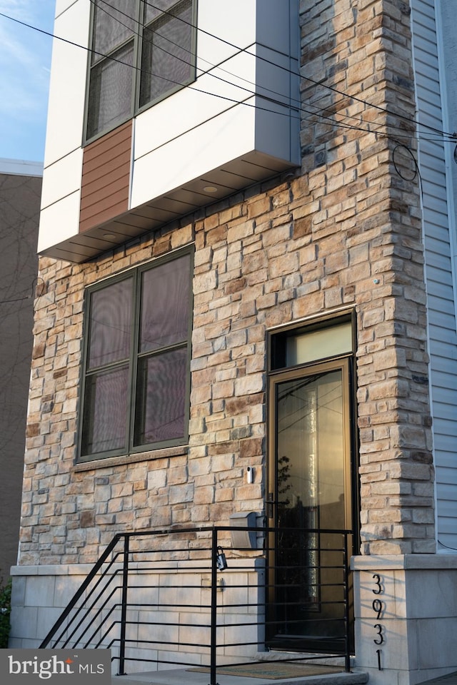property entrance with stone siding