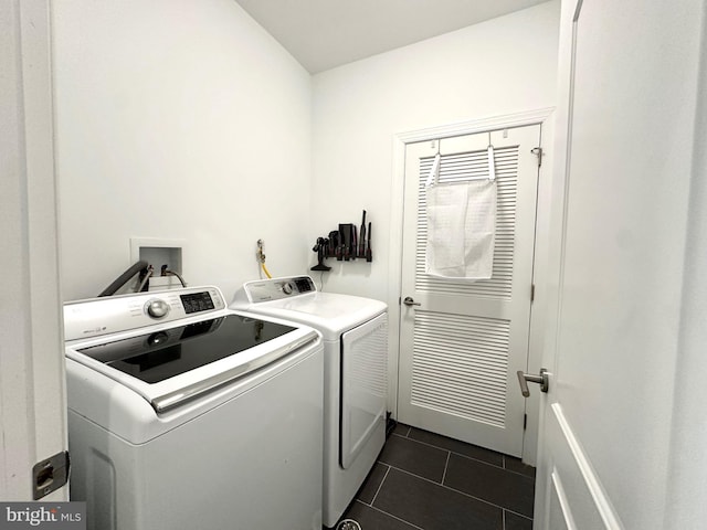 washroom featuring washer and dryer and dark tile patterned floors