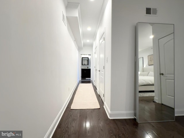 corridor featuring wood finished floors and baseboards