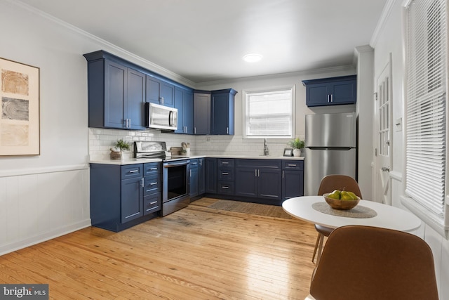 240 W Philadelphia St, York, PA 17403 - kitchen featuring stainless steel appliances, ornamental molding, light wood finished floors, blue cabinets, and light countertops