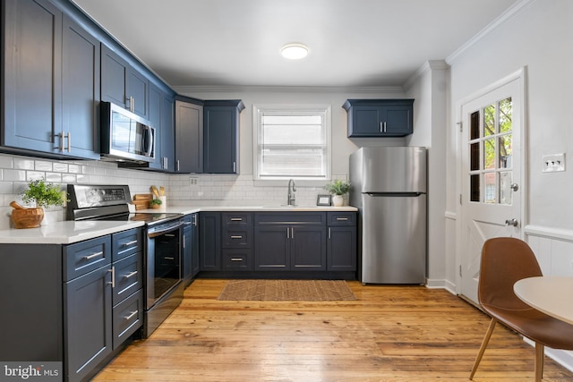 240 W Philadelphia St, York, PA 17403 - kitchen featuring a sink, stainless steel appliances, ornamental molding, light countertops, and decorative backsplash