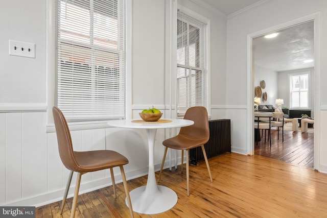240 W Philadelphia St, York, PA 17403 - dining space with radiator, ornamental molding, wainscoting, wood-type flooring, and a decorative wall