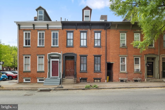 240 W Philadelphia St, York, PA 17403 - view of front of property featuring cooling unit, brick siding, a chimney, and entry steps