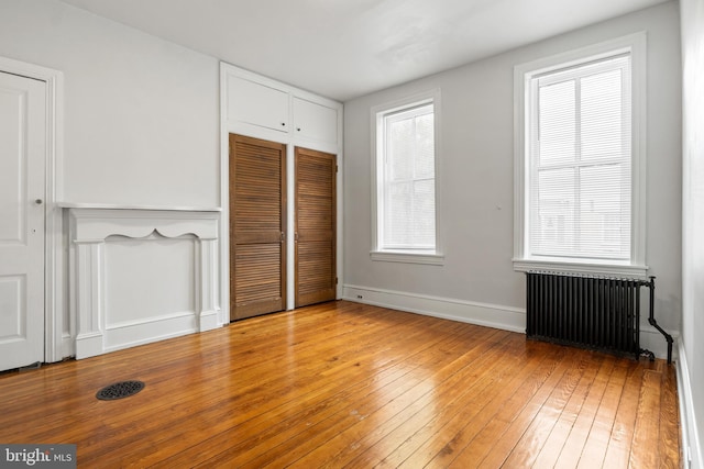240 W Philadelphia St, York, PA 17403 - unfurnished bedroom featuring radiator, baseboards, light wood-type flooring, and a closet