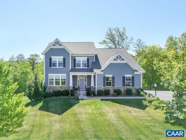 craftsman house with stone siding and a front yard