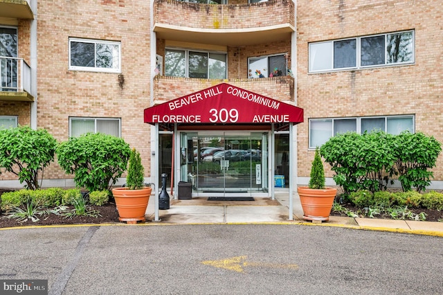 view of exterior entry featuring brick siding