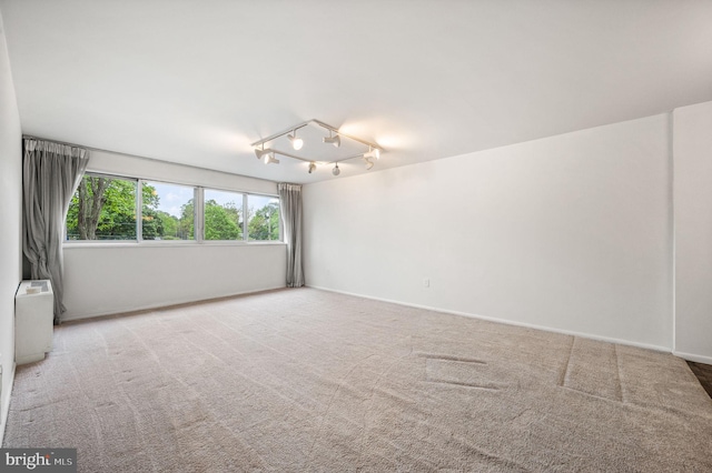 carpeted empty room featuring baseboards