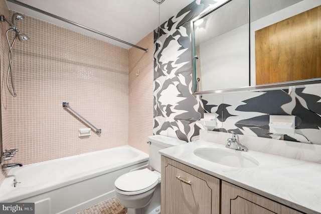 bathroom with washtub / shower combination, vanity, and toilet