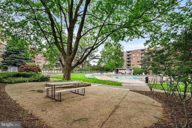surrounding community with a patio area, a swimming pool, and fence