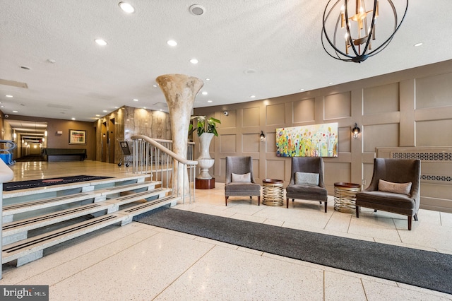 common area featuring a decorative wall, stairs, a textured ceiling, and recessed lighting