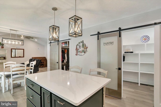 172 Charles St, Hanover, PA 17331 - kitchen with a barn door, light wood finished floors, a kitchen island, light countertops, and open floor plan