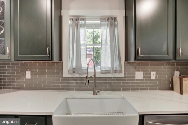 172 Charles St, Hanover, PA 17331 - kitchen with a sink, stainless steel dishwasher, light stone counters, decorative backsplash, and glass insert cabinets