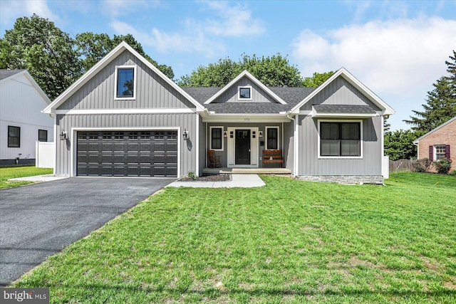 172 Charles St, Hanover, PA 17331 - view of front of house featuring asphalt driveway, covered porch, a shingled roof, a front lawn, and an attached garage