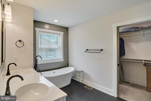 172 Charles St, Hanover, PA 17331 - bathroom with a freestanding bath, double vanity, baseboards, a spacious closet, and recessed lighting