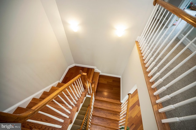 stairs with wood finished floors and baseboards