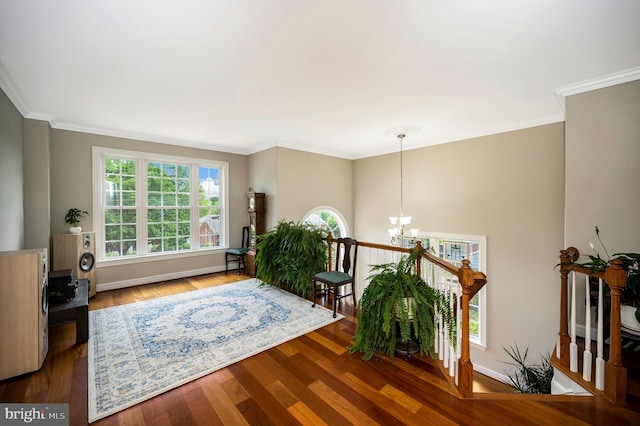 sitting room featuring a chandelier, wood finished floors, crown molding, and baseboards