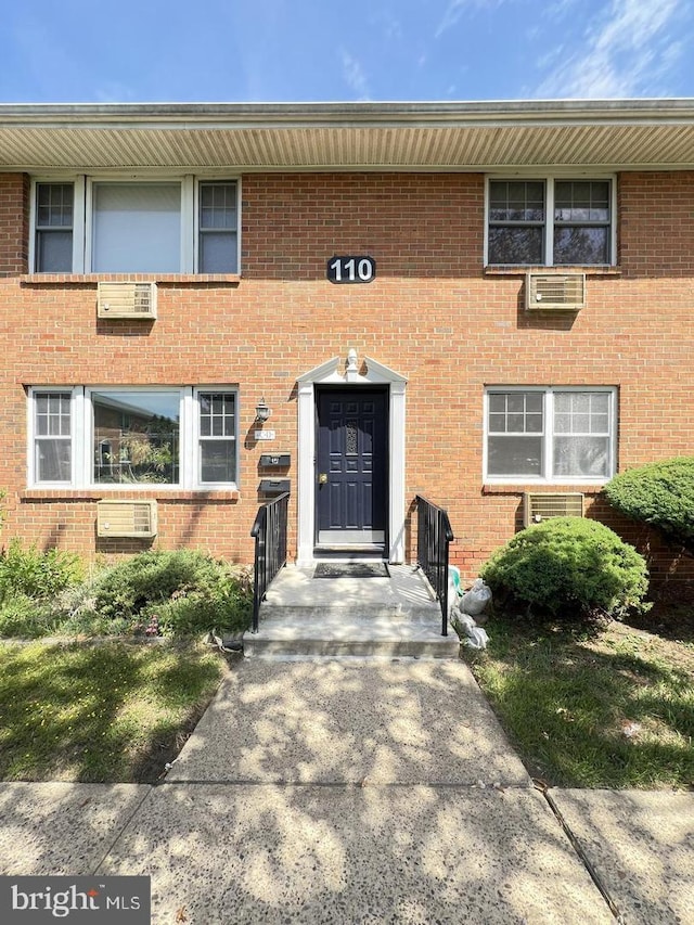 view of exterior entry featuring brick siding