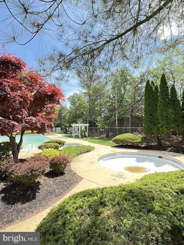 view of property's community with fence and a swimming pool