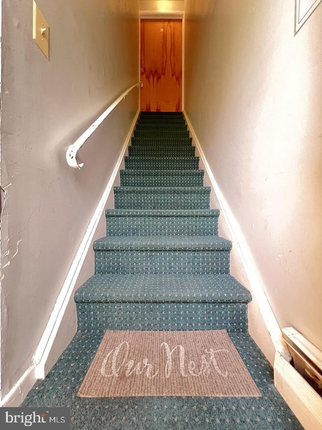 stairs featuring carpet flooring and baseboards