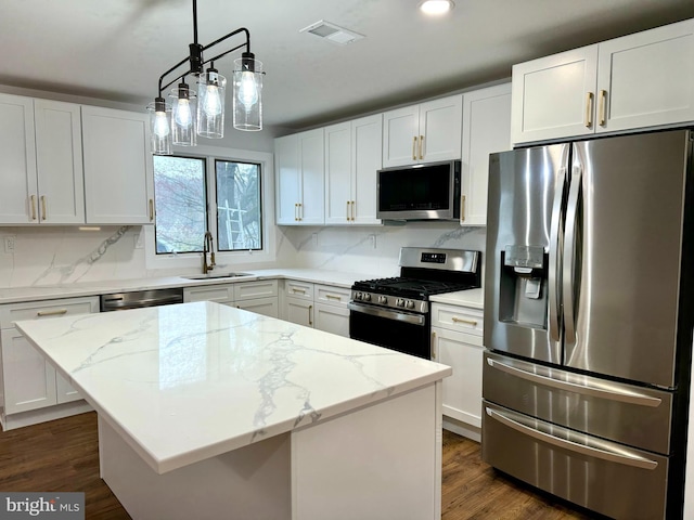 kitchen with a sink, stainless steel appliances, white cabinetry, and visible vents